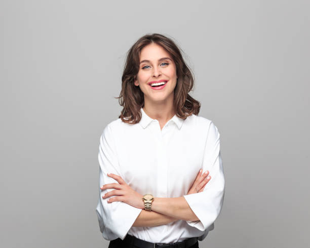 Woman smiling in a white button-up shirt, perfect for staying cool in hot weather.