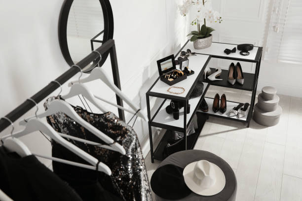 A minimalistic wardrobe with essential clothing, accessories, and shoes organized neatly in a modern room.